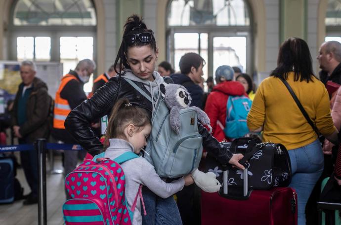 Una mujer y su hija, junto con otros refugiados de Ucrania, esperan en la estación de Przemysl, Polonia.