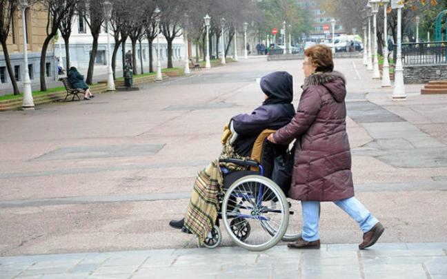 Una mujer atendiendo a una persona dependiente durante un paseo