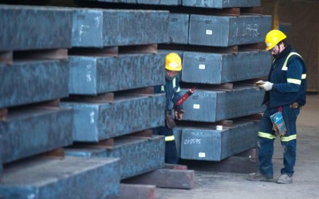 Dos operarios, en su puesto de trabajo.