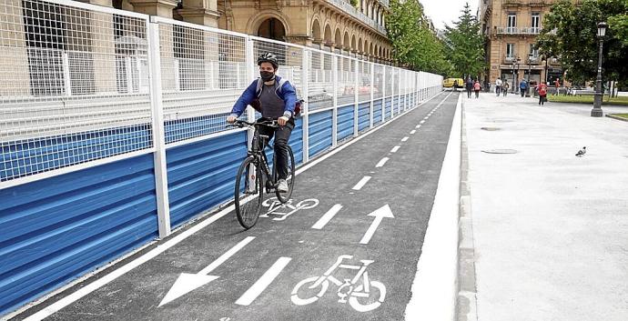 Un ciclista transita, ayer, por el nuevo tramo de bidegorri junto a la acera de la plaza del Buen Pastor, liberada de obras.