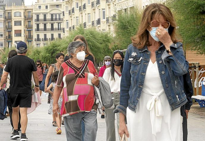 Varias personas, protegidas con mascarilla, pasean por Donostia. Foto: Ruben Plaza