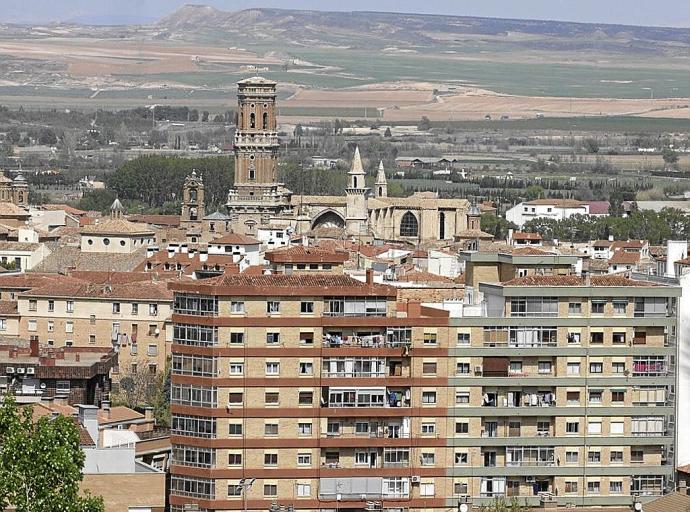 Un edificio de Tudela, con la catedral y el Ebro al fondo.