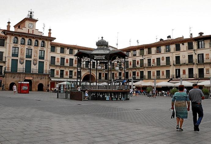 Una pareja pasea por la plaza de Los Fueros de Tudela.