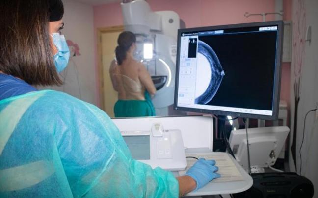Una mujer se somete a una mamografía. Una mujer se somete a una mamografía.