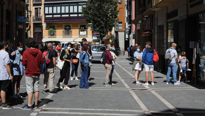 Turistas haciendo cola en la calle, junto a la Oficina de Turismo de San Saturnino.