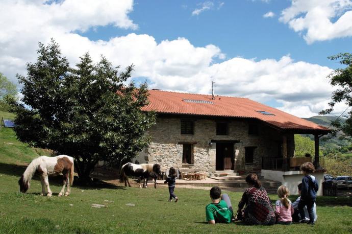 Una familia en el exterior de la casa rural Sastizar, en Areso.