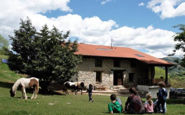 Una familia en el exterior de la casa rural Sastizar, en Areso.