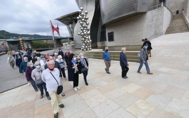 Un grupo de turistas pasea por los alrededores del museo Guggenheim Un grupo de turistas pasea por los alrededores del museo Guggenheim