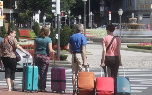 Turistas con sus maletas por el centro de Bilbao