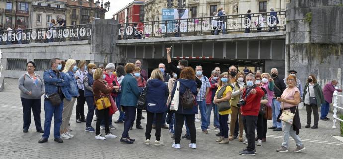 Un grupo de turistas atiende las indicaciones del guía en El Arenal de Bilbao, ayer domingo durante la primera jornada del 'puente'.