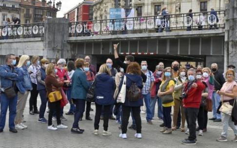 Un grupo de turistas atiende las indicaciones del guía en El Arenal de Bilbao, ayer domingo durante la primera jornada del 'puente'.