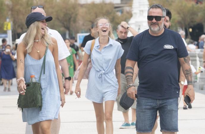 Turistas paseando divertidos por el paseo de La Concha.