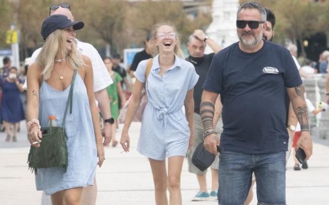 Turistas paseando divertidos por el paseo de La Concha.