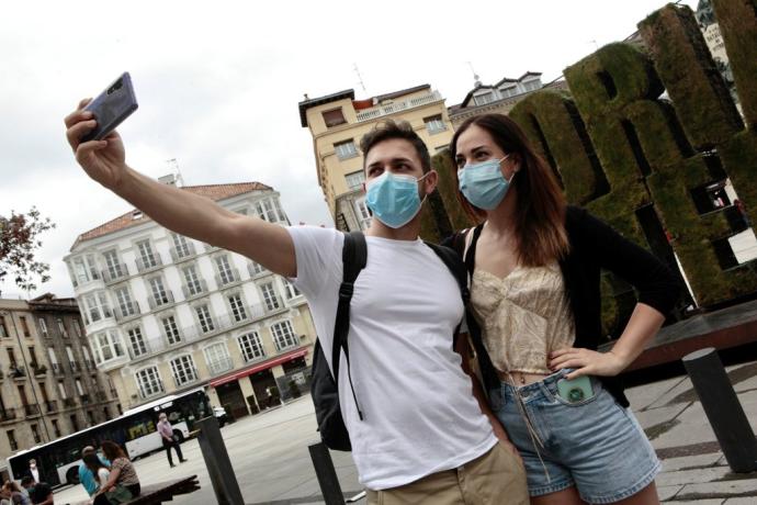 Turistas se fotografían junto a la escultura vegetal de la plaza de la Virgen Blanca.