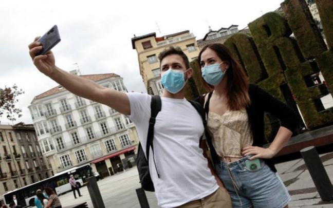Turistas se fotografían junto a la escultura vegetal de la plaza de la Virgen Blanca.