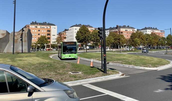 Un autobús atraviesa por el interior de la rotonda de Telefónica, junto al edificio del HUA