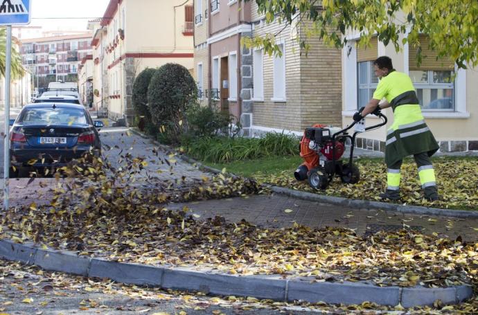 Recogiendo las hojas caídas de los árboles en una calle de la Txantrea.