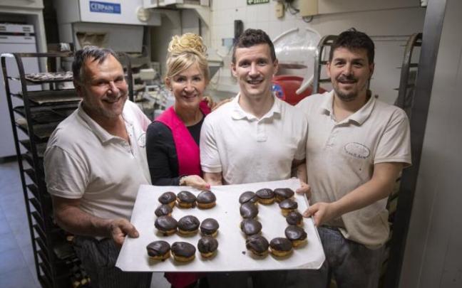 La familia posa con unas magdalenas que hacen un 50, por el aniversario