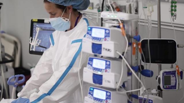 Una profesional sanitaria atiende a una paciente con covid- 19 en la UCI.