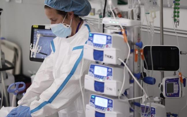 Una profesional sanitaria atiende a una paciente con covid- 19 en la UCI. Una profesional sanitaria atiende a una paciente con covid- 19 en la UCI.
