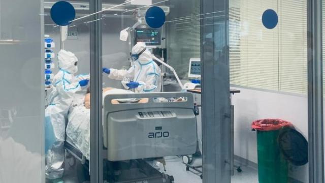 Sanitarios atienden a un paciente en la UCI de un hospital.