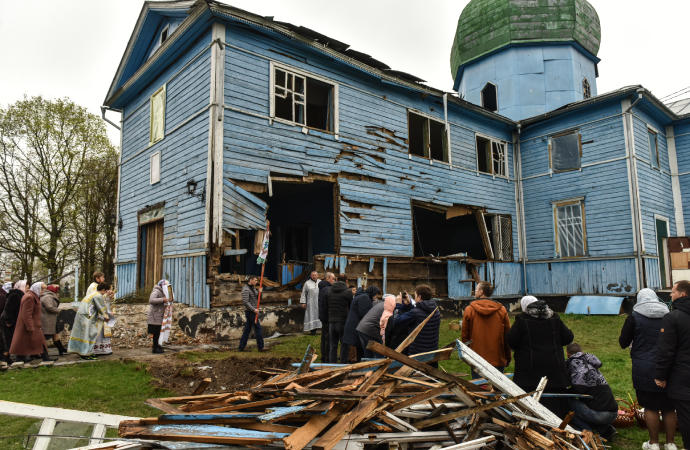Varios ucranianos celebran la Pascua ortodoxa ante una iglesia derruida.