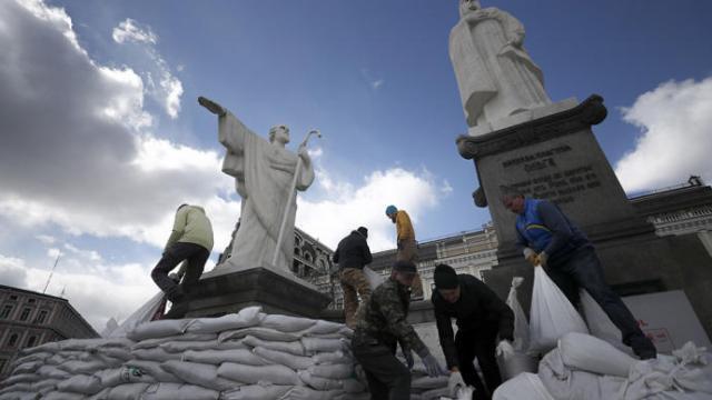Voluntarios ucranianos protegen con sacos varios monumentos en Kiev.