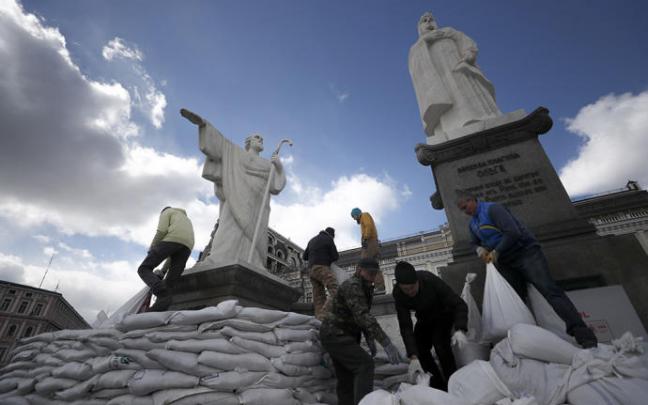 Voluntarios ucranianos protegen con sacos varios monumentos en Kiev.