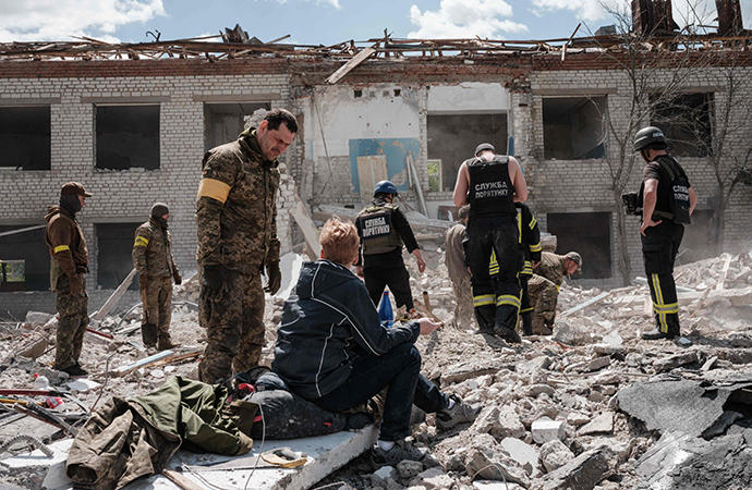 Soldados ucranianos buscan supervivientes entre los escombros de una escuela destruida.