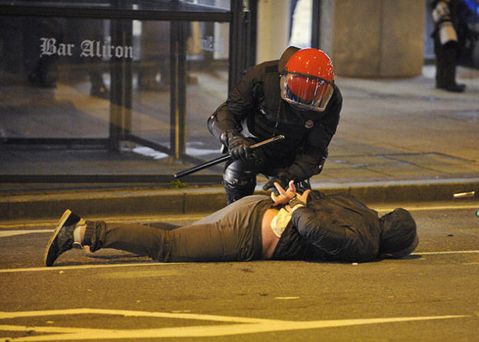 Un agente de la Ertzaintza esposa a un joven en los alrededores de un estadio de fútbol.