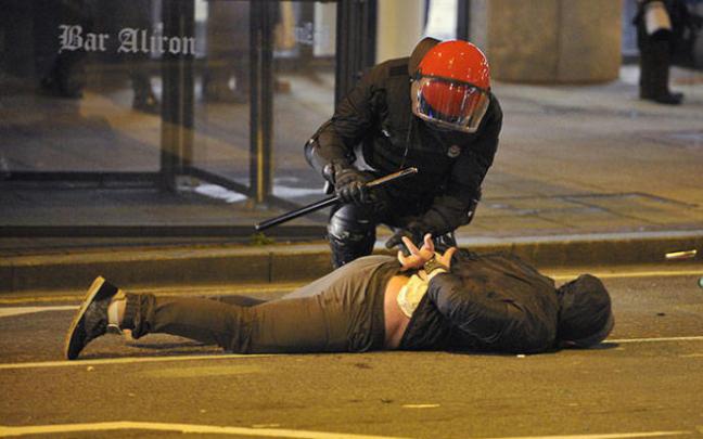 Un agente de la Ertzaintza esposa a un joven en los alrededores de un estadio de fútbol.