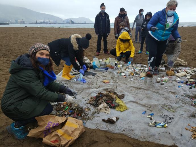 Un grupo de voluntarios retira basuras de la playa de Ereaga, en Getxo.