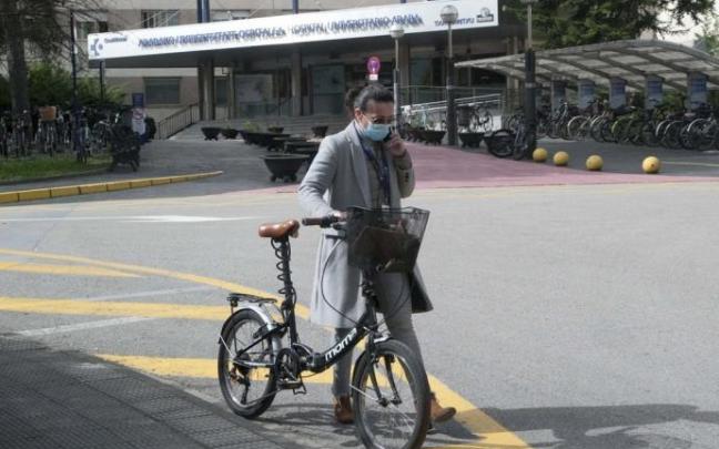 Una mujer con mascarilla andando por la calle.
