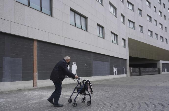 Una persona mayor sin relación con la información andando por la calle.