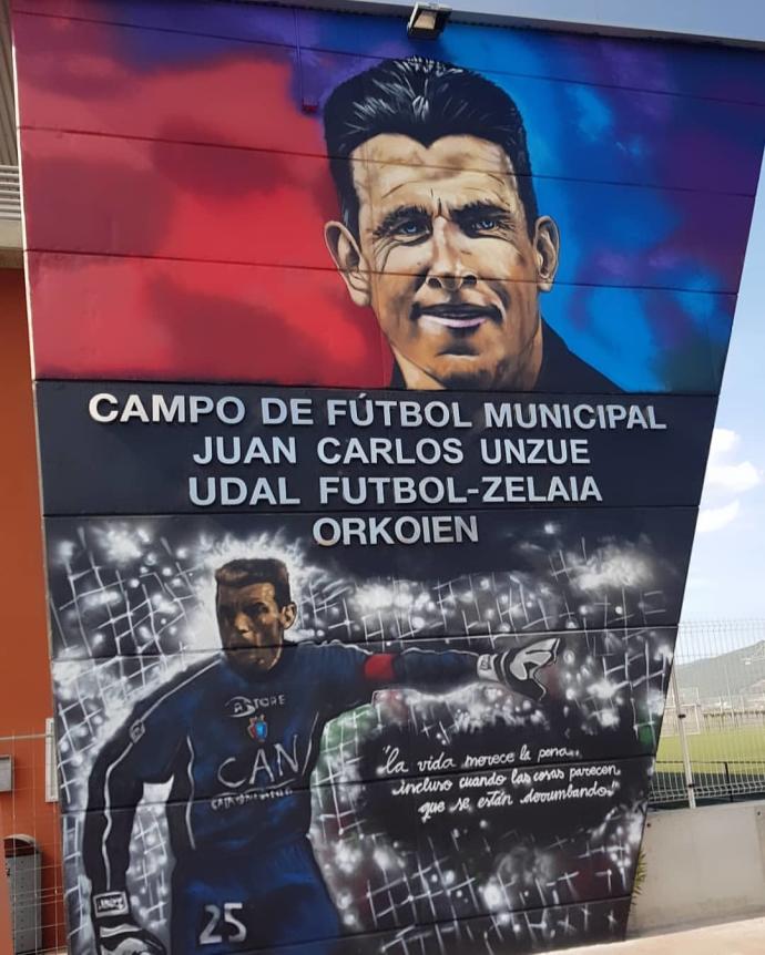 Acceso al "Campo de Futbol Municipal de Orkoien Juan Carlos Unzué", con el grafiti de Koldo Calvo.