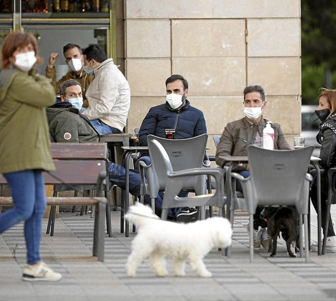 Personas con mascarilla en una terraza. Foto: Borja Guerrero