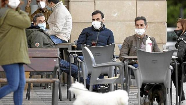 Personas con mascarilla en una terraza. Foto: Borja Guerrero