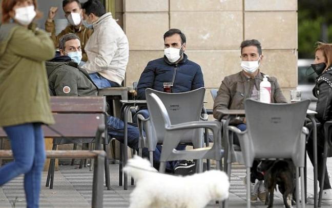 Personas con mascarilla en una terraza. Foto: Borja Guerrero