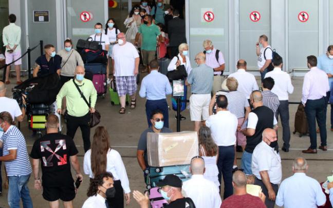Turistas se disponen a coger un vuelo para disfrutar de sus vacaciones. Turistas se disponen a coger un vuelo para disfrutar de sus vacaciones.