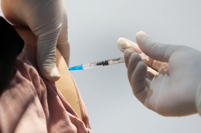 Un sanitario administra una vacuna contra la covid-19
