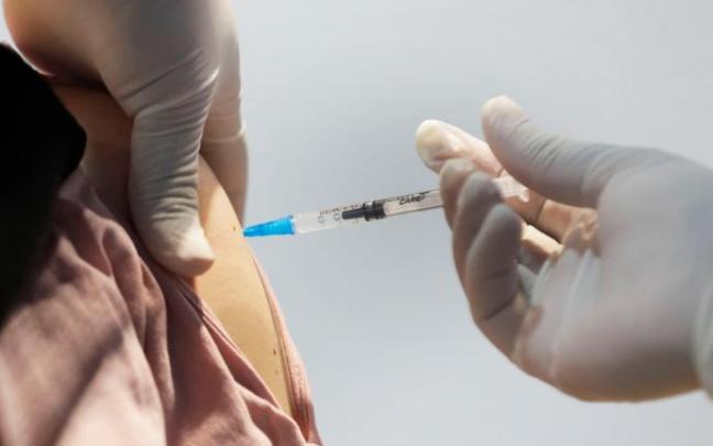 Un sanitario administra una vacuna contra la covid-19