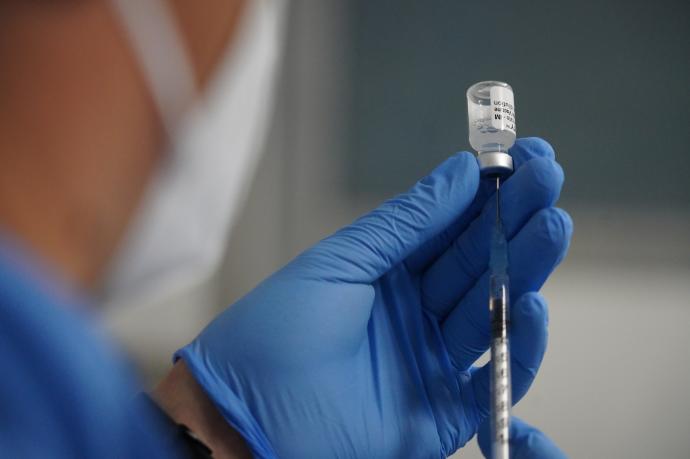Un sanitario prepara una vacuna contra la covid-19.