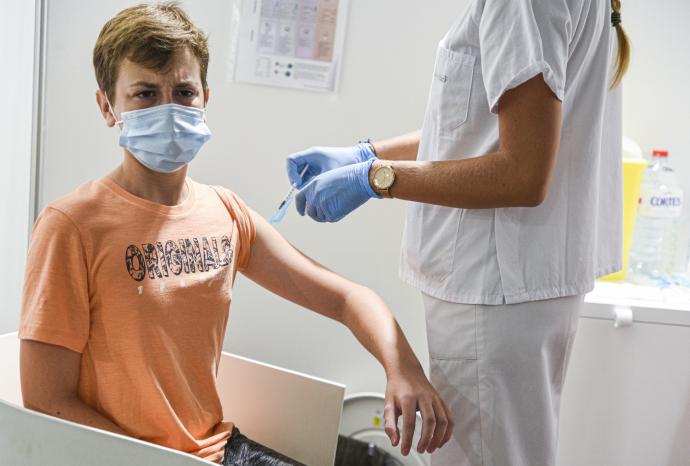 Un menor de 15 años recibe la primera dosis de la vacuna.