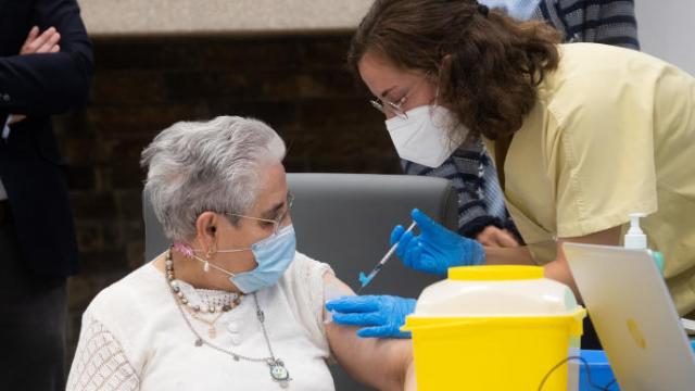 Una mujer recibe la vacuna de refuerzo