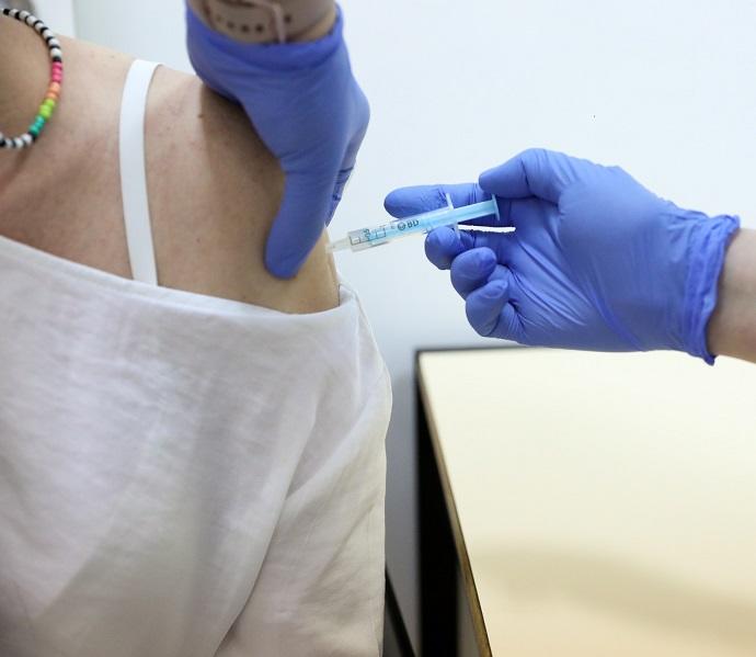 Una sanitaria inyecta a una paciente una dosis de la vacuna contra el coronavirus.