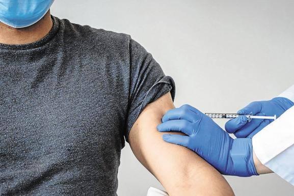 Un hombre se dispone a recibir una dosis de la vacuna contra la covid-19.
