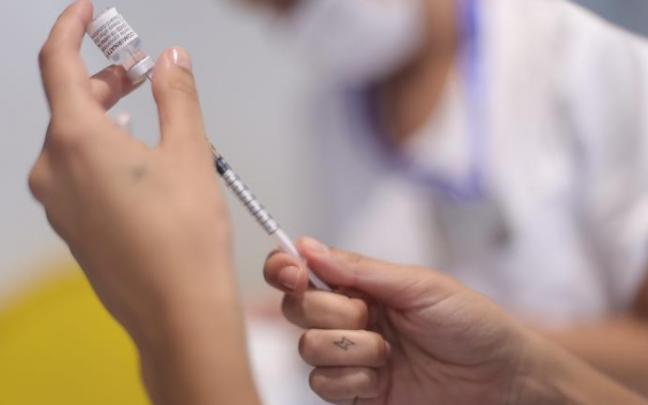 Un sanitario prepara una vacuna.