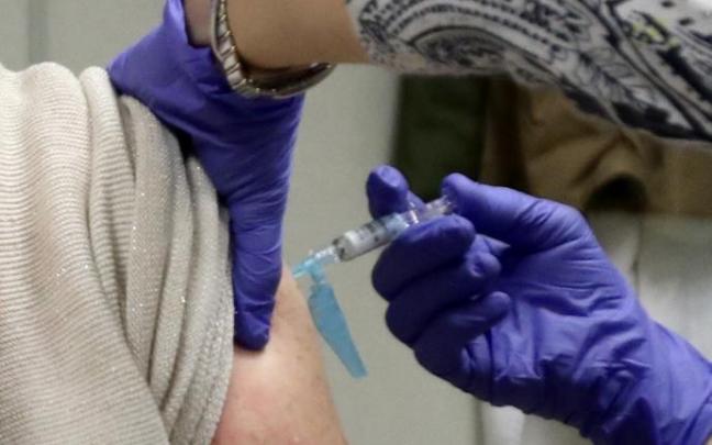 Enfermera poniendo una vacuna.