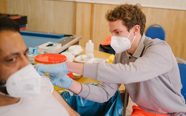 Un sanitario vacuna a un hombre.