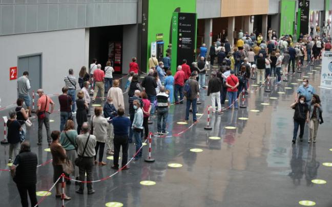 Decenas de personas hacen cola para recibir la vacuna en el Bilbao Exhibition Center.